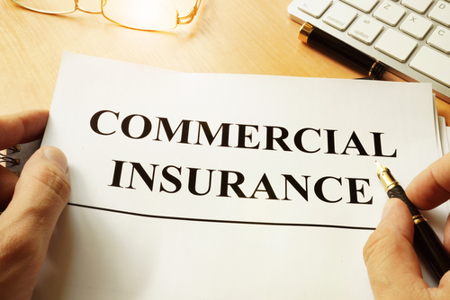 person holding paper that says commercial insurance